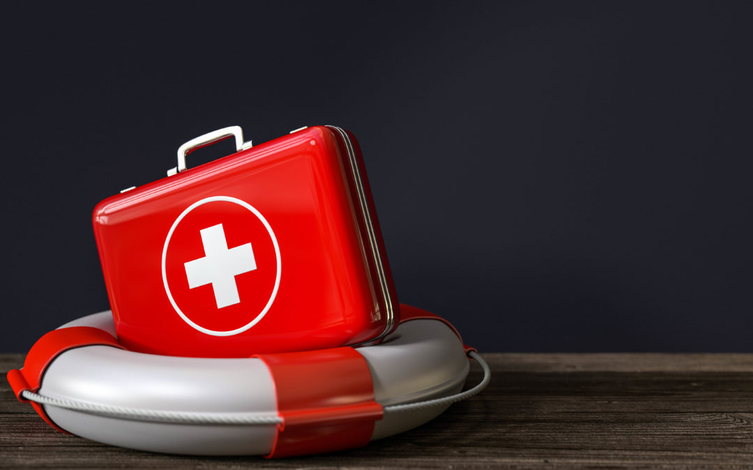 Red First Aid kit with white cross sitting angled in a white life ring