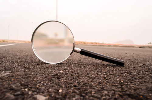 magnifying glass on it's edge in the middle of the road